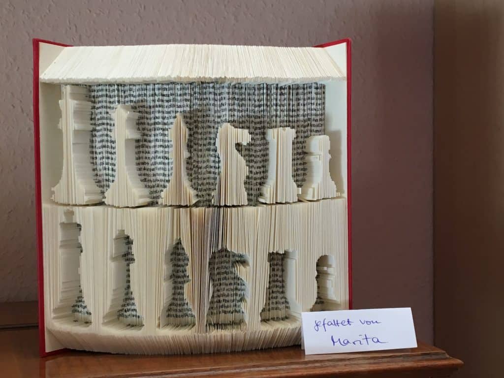 Gefaltetes Buch mit Schachfiguren