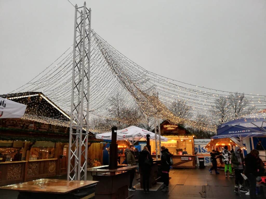 ein kleiner Weihnachtsmarkt neben der Eislaufbahn