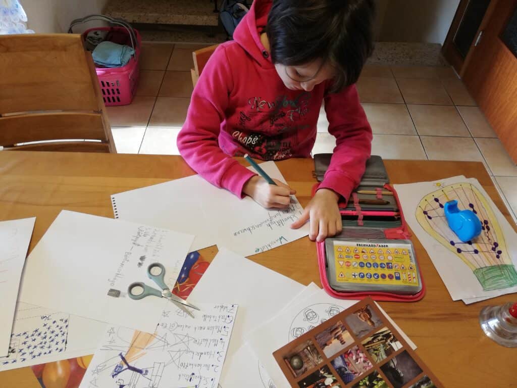 Die andere Tochter sitzt am Tisch und schreibt auch